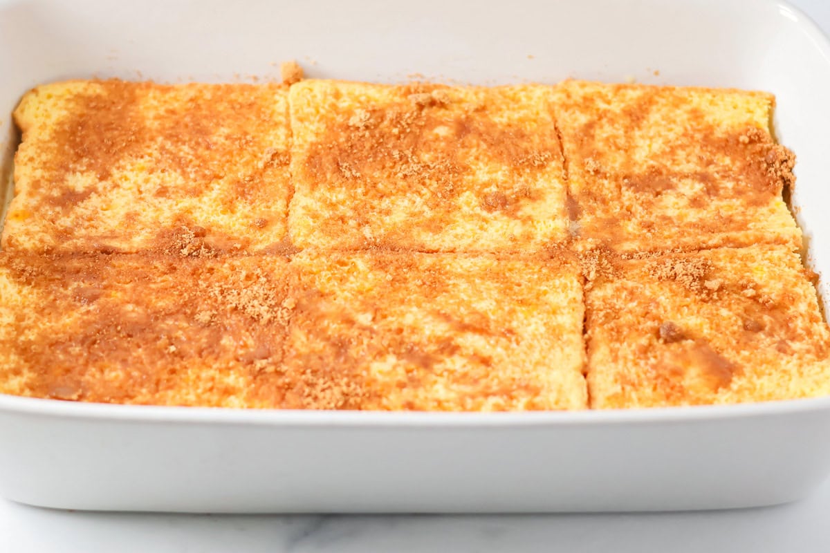 Sprinkling cinnamon on top of the  bread layer.