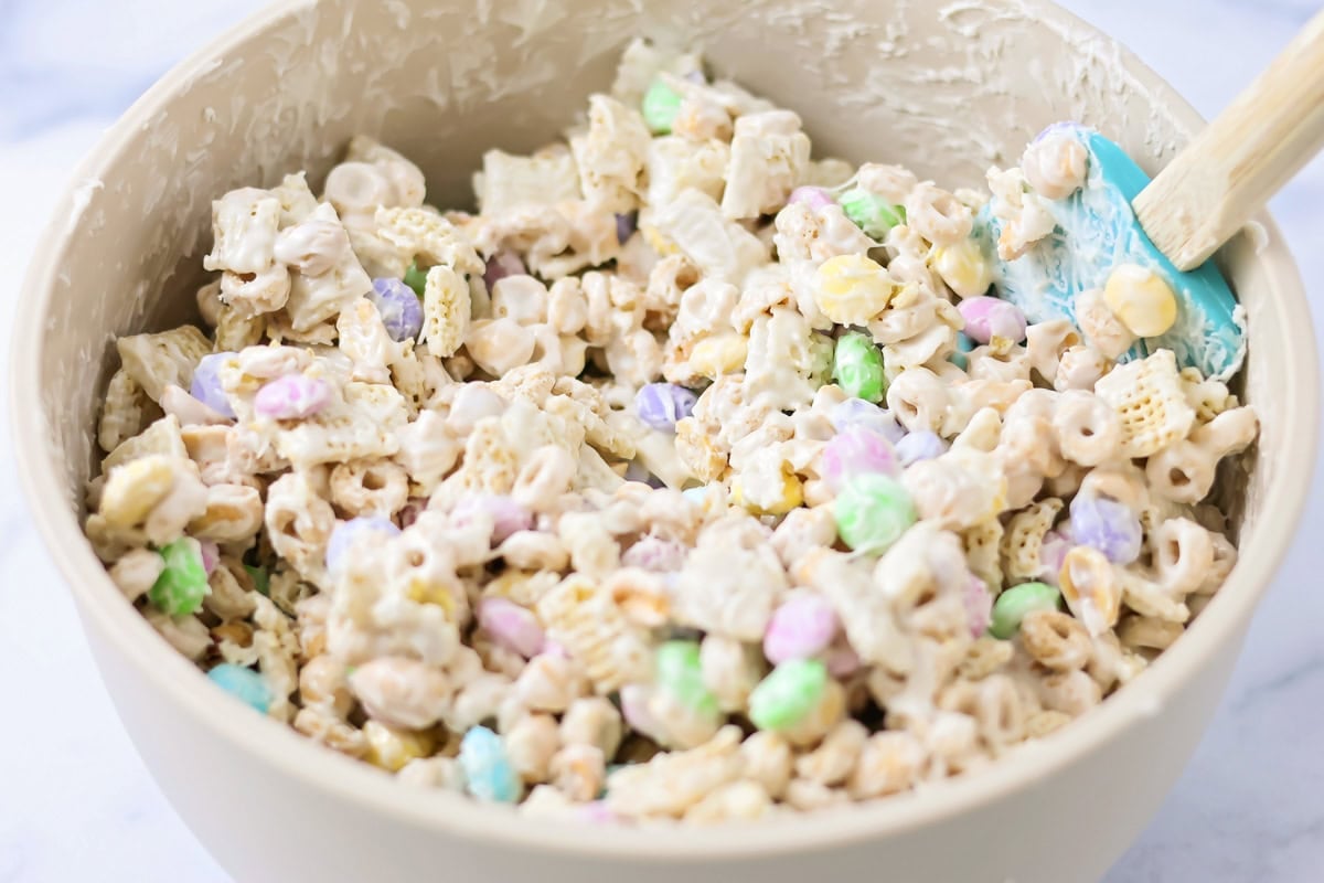 Stirring to coat the cereal mixture with candy coating.