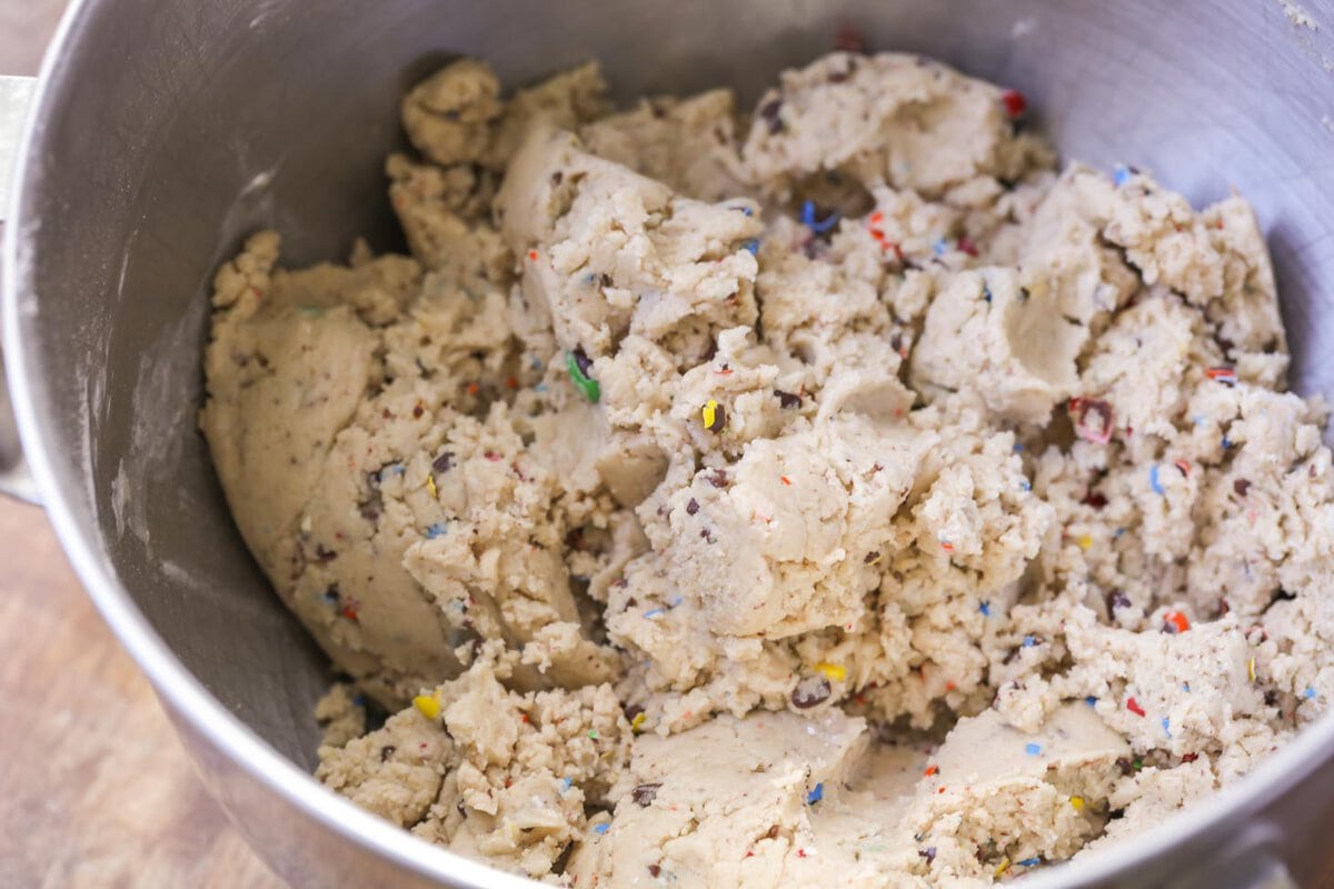 Peanut butter m&m cookie dough in the bowl of a stand mixer.