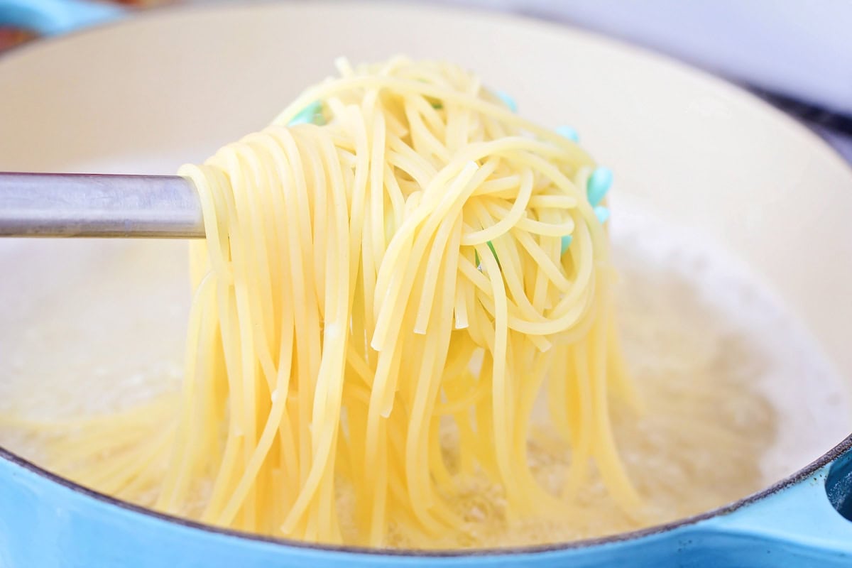 Spaghetti Noodles being cooked in water in pot.