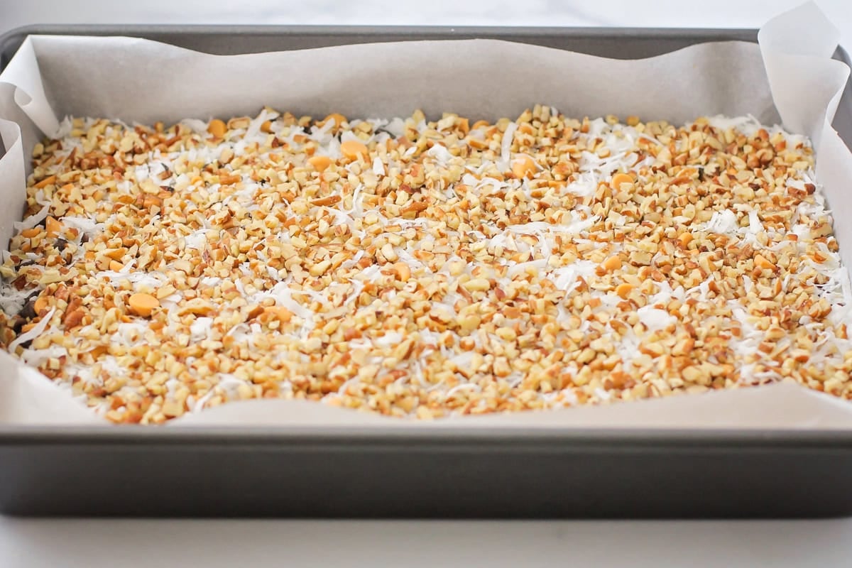 This homemade 7 layer bars recipe is rich, gooey, and loaded with chocolate, coconut, and nuts for the ultimate, easy dessert! 7 layer bars recipes ready to be baked.