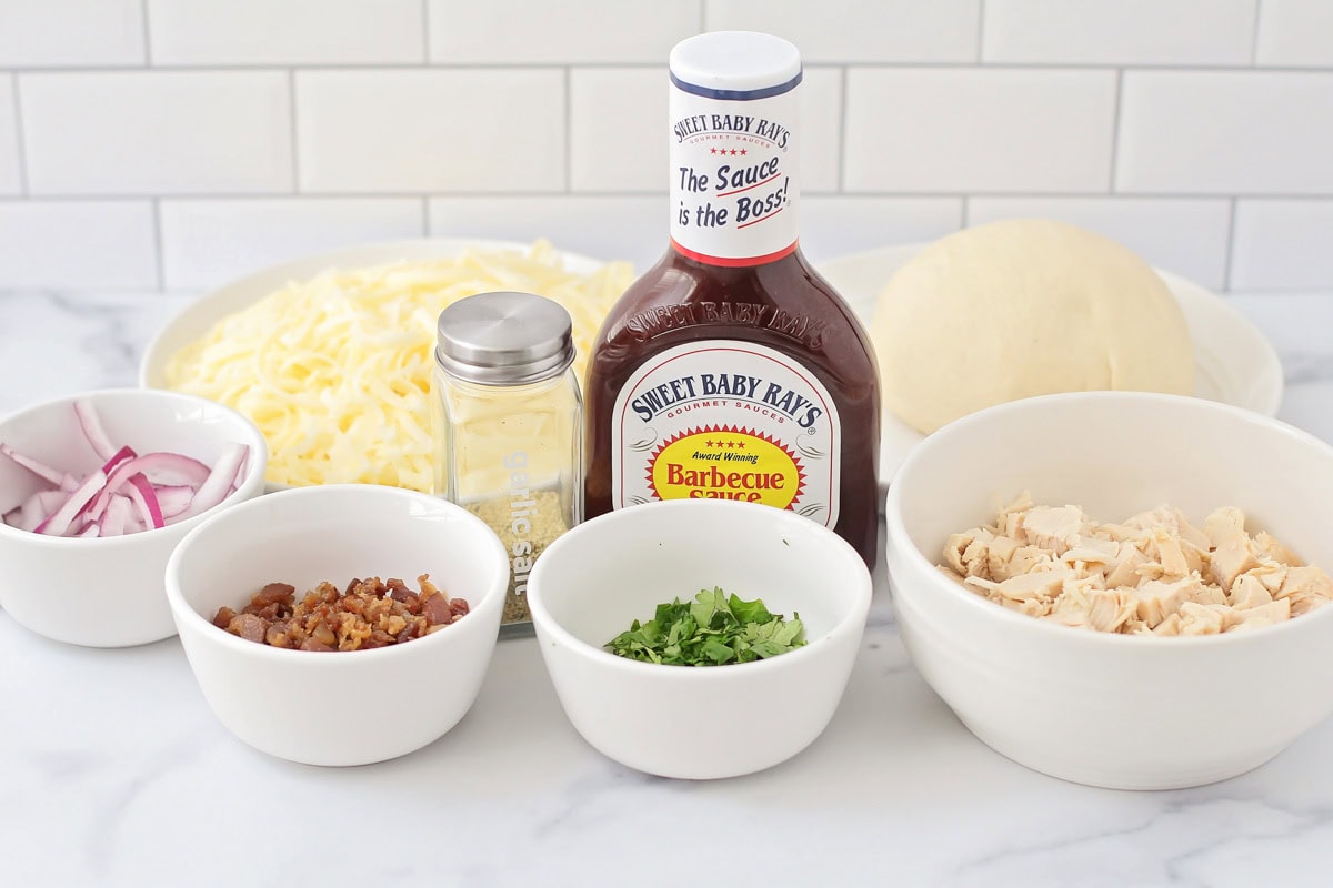 Ingredients for bbq chicken pizza recipe on a kitchen counter.