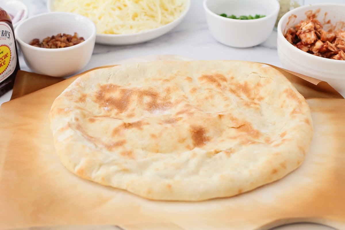 A cooked pizza crust on a pizza peel.