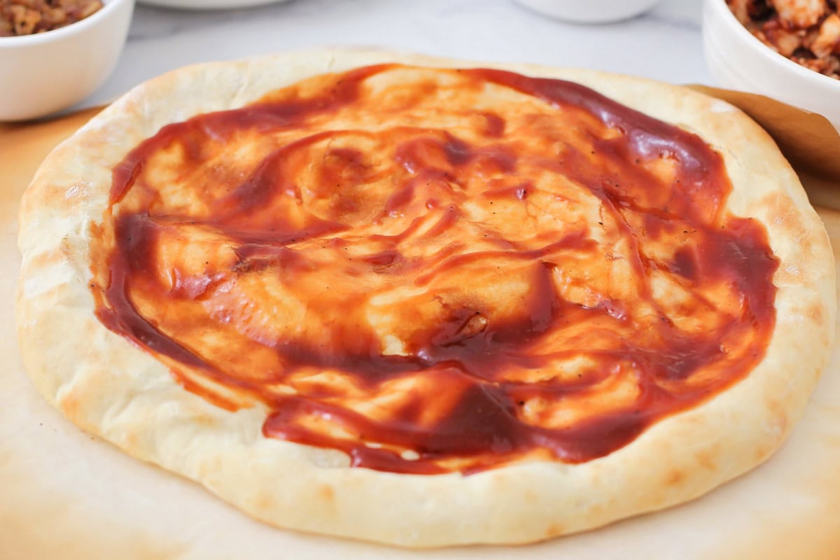 BBQ sauce spread on the pizza crust.
