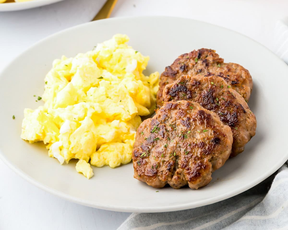 Breakfast sausage recipe served with scrambled eggs.