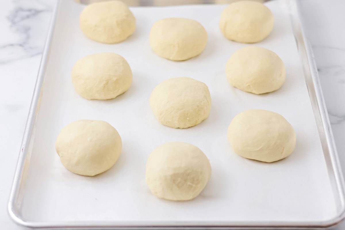 Dough balls on a lined baking sheet.