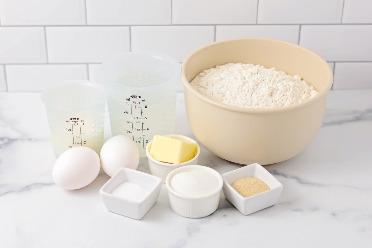 Brioche bun recipe ingredients on a kitchen counter.