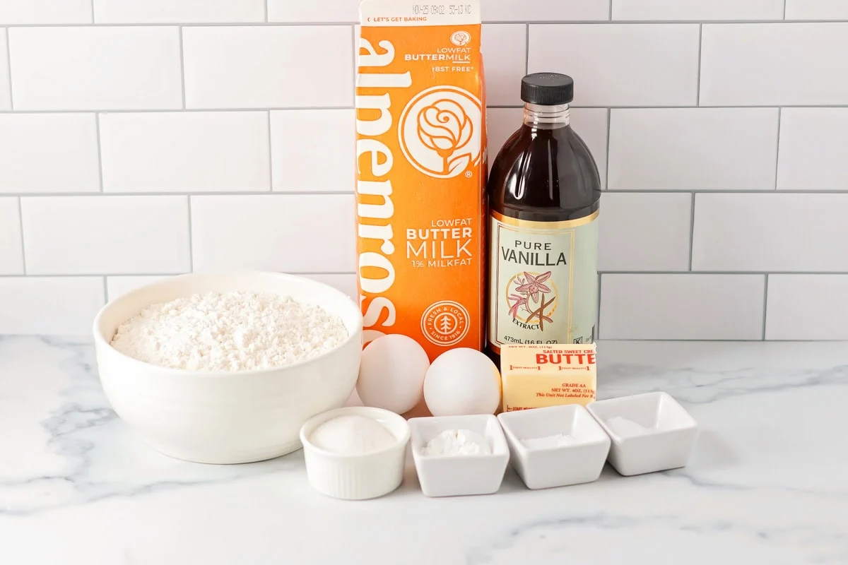 There's nothing better than big, fluffy buttermilk waffles first thing in the morning! This will be your new favorite breakfast recipe!! Ingredients for buttermilk waffles on a white countertop.