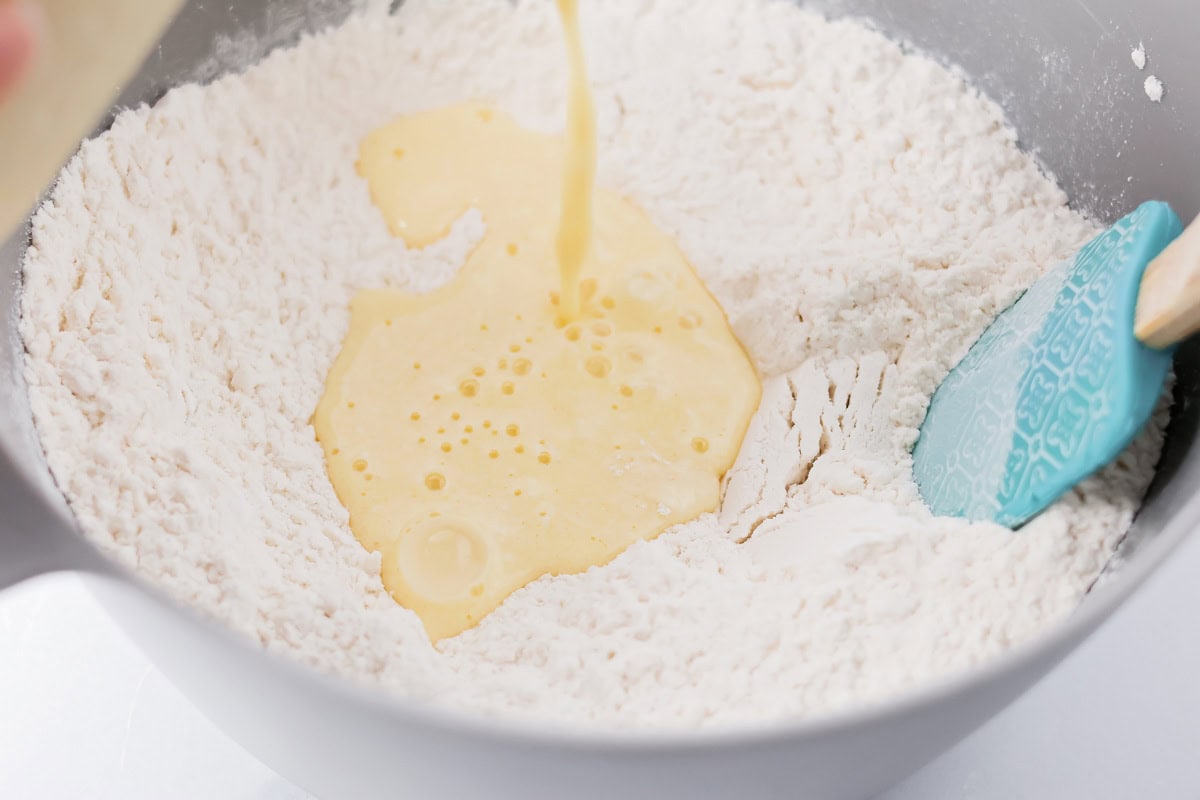 Our no-fail recipe for delicious, fluffy buttermilk waffles is morning perfection every time - guaranteed! Adding dry and wet ingredients for buttermilk waffles to a mixing bowl.