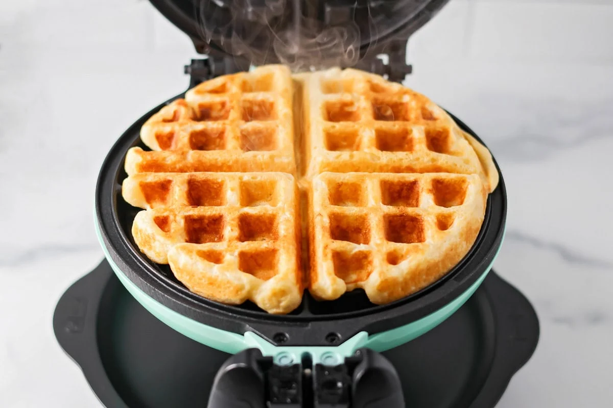 Our no-fail recipe for delicious, fluffy buttermilk waffles is morning perfection every time - guaranteed! A cooked buttermilk waffle in a waffle maker.