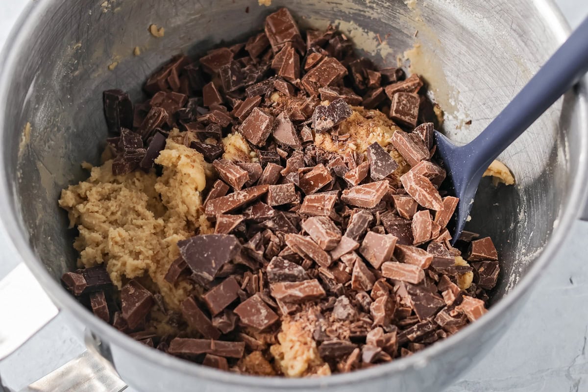 Adding chocolate chunks to the cookie dough.