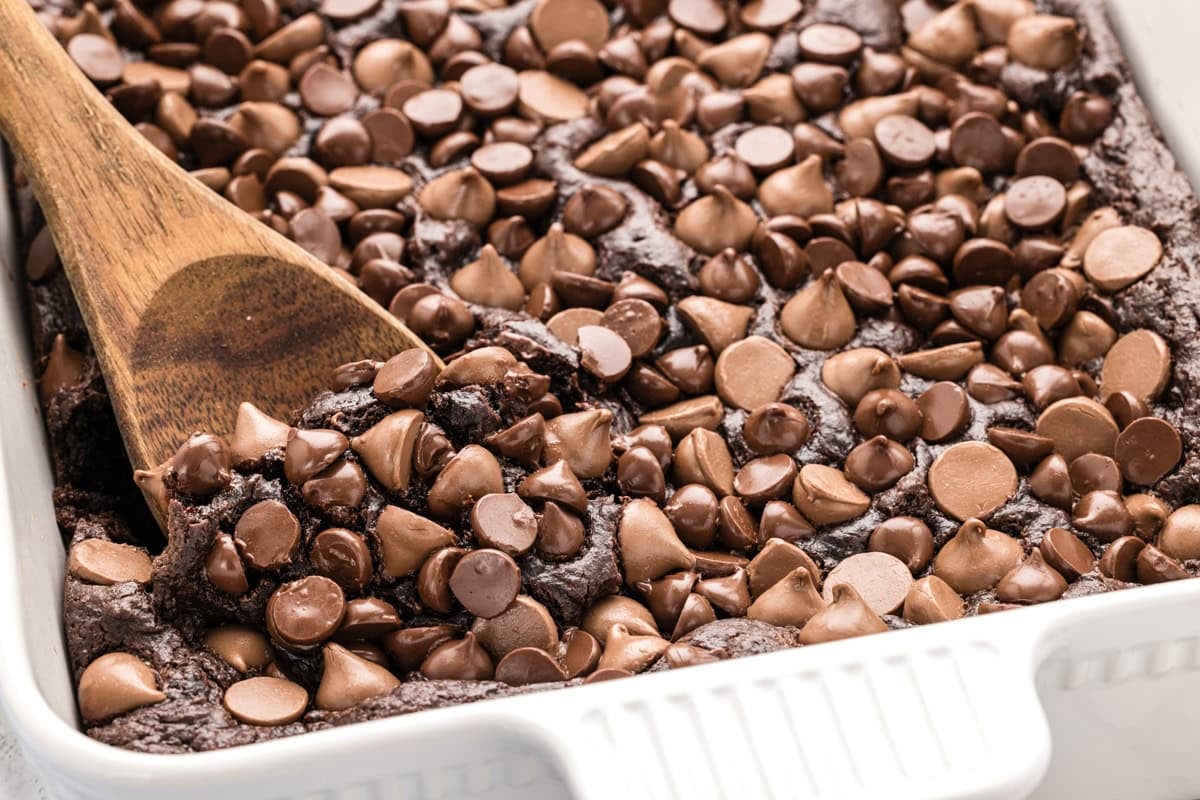 A wooden spoon scooping a serving of chocolate dump cake.