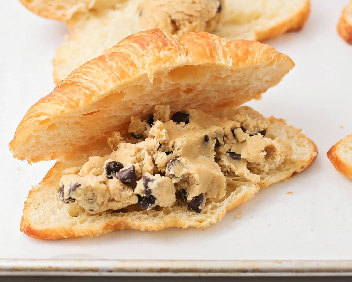 Filling a split croissant with cookie dough.
