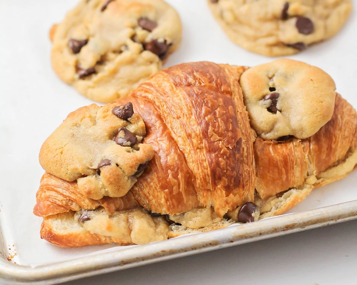 Close up of cookie croissants on a lined baking sheet.