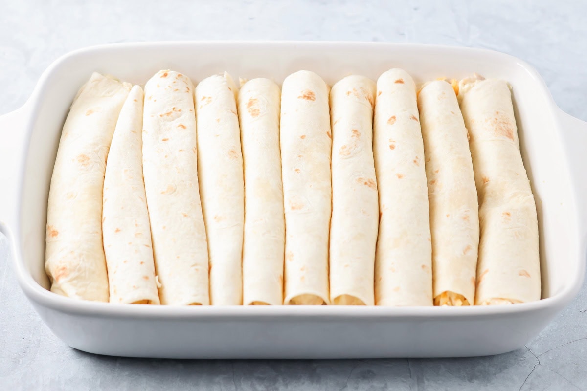 Rolled tortillas in a baking dish.