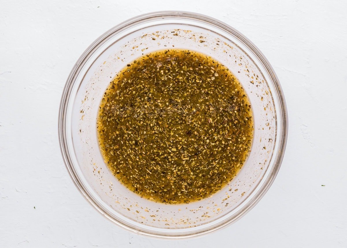 Greek dressing mixed in a glass bowl.