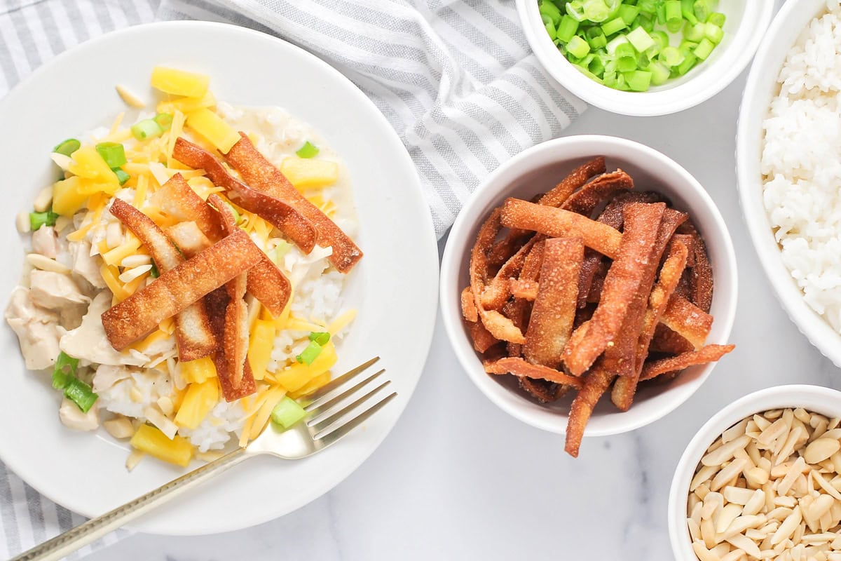 Assembling Hawaiian haystacks in a white bowl.