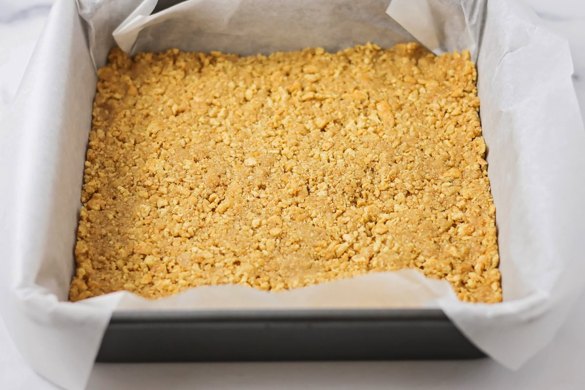 Graham cracker crust pressed into a lined baking dish.