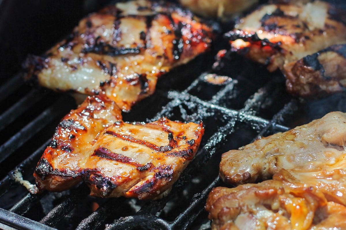 Grilled Huli Huli chicken is juicy, smoky, and glazed with a sweet and tangy Hawaiian-style marinade! Serve it alone or on rice or noodles. Grilling marinated chicken thighs.