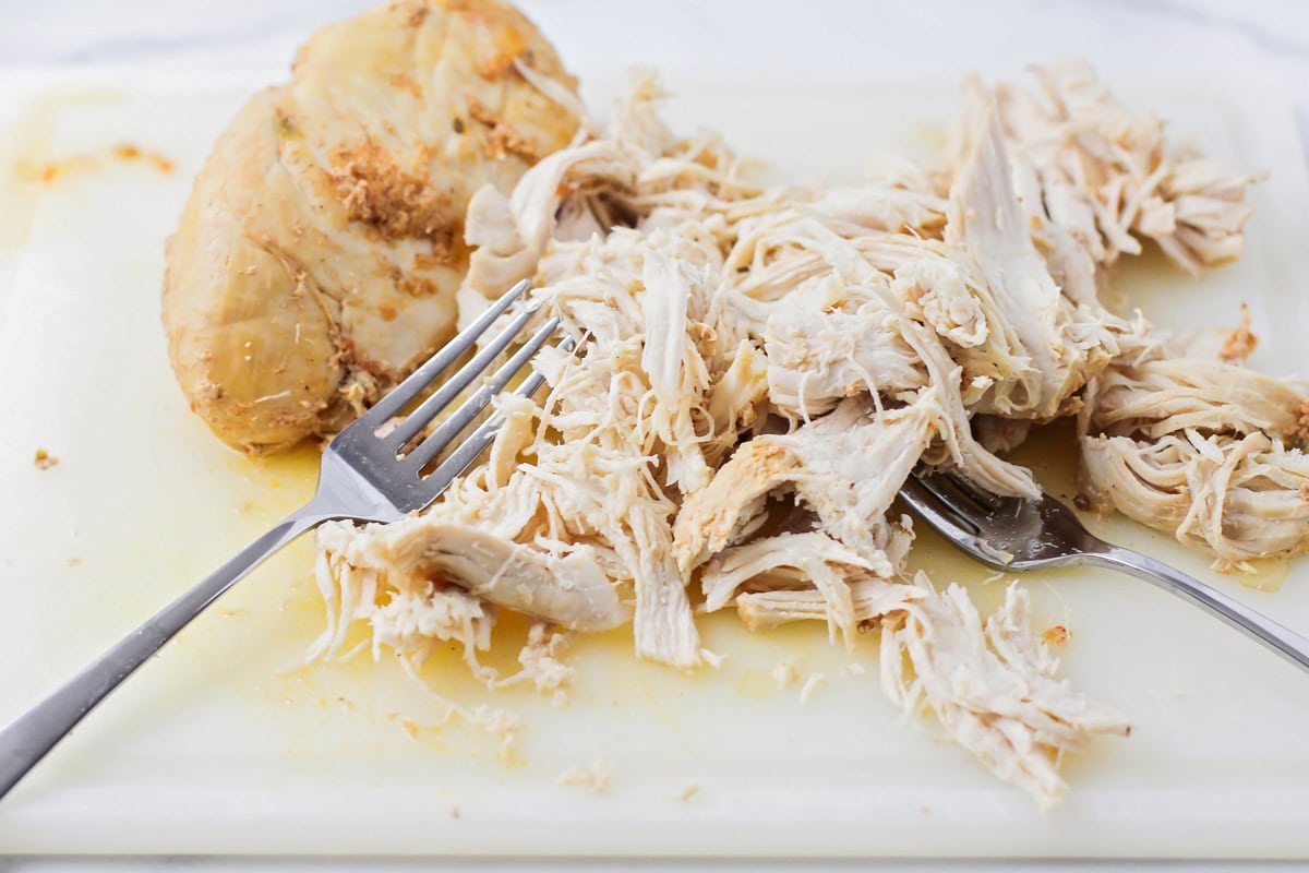 Shredded chicken on a cutting board.