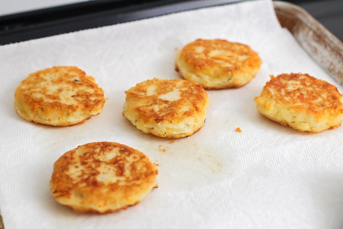 Potato pancakes draining on a paper towel.