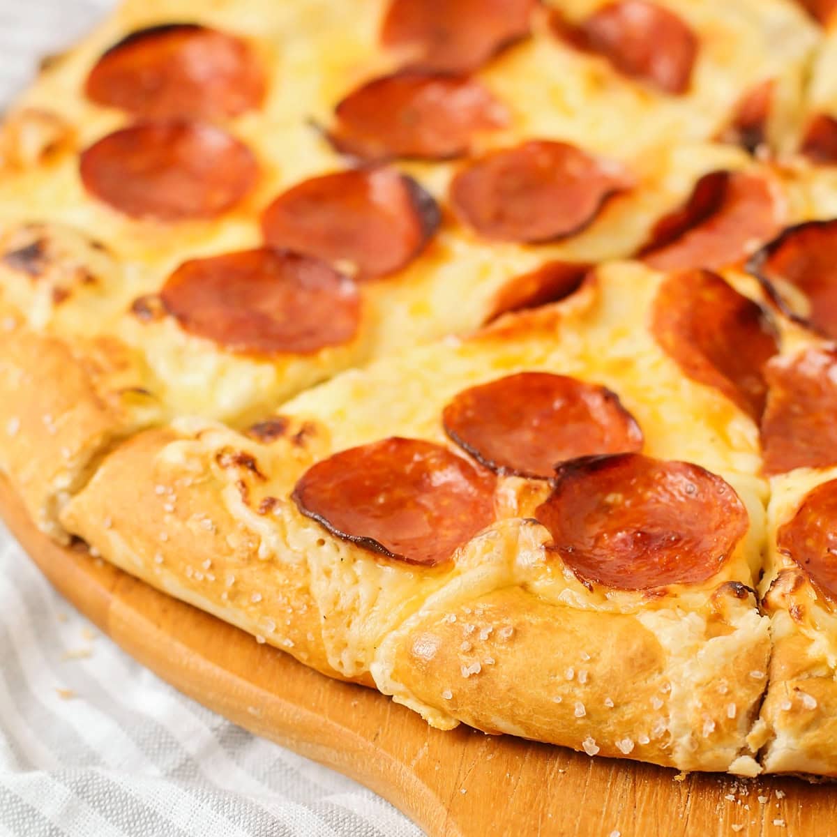 Close up of pretzel crust pizza recipe on a pizza peel.