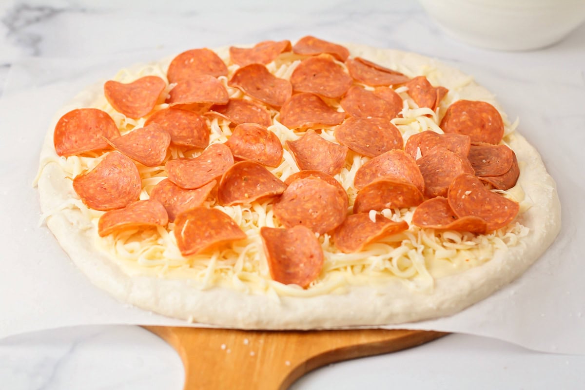 Cheese and pepperoni on a pizza crust.