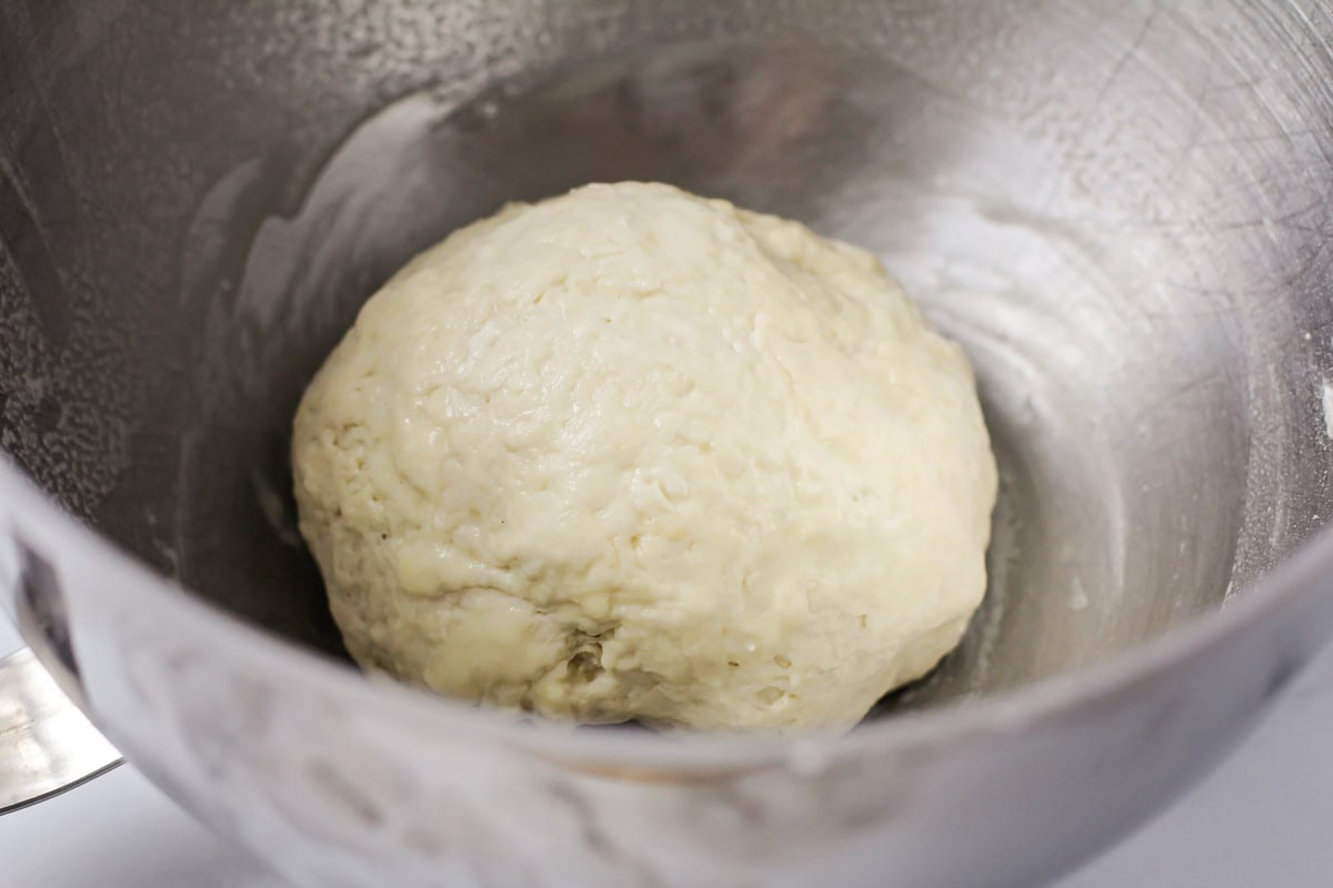 Dough ball in a metal bowl.