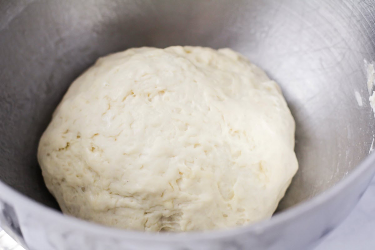 Dough rising in a metal bowl.