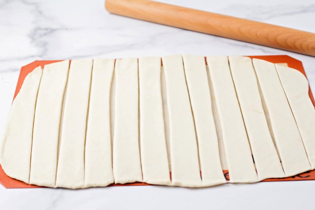 Dough cut into strips on a silpat mat.