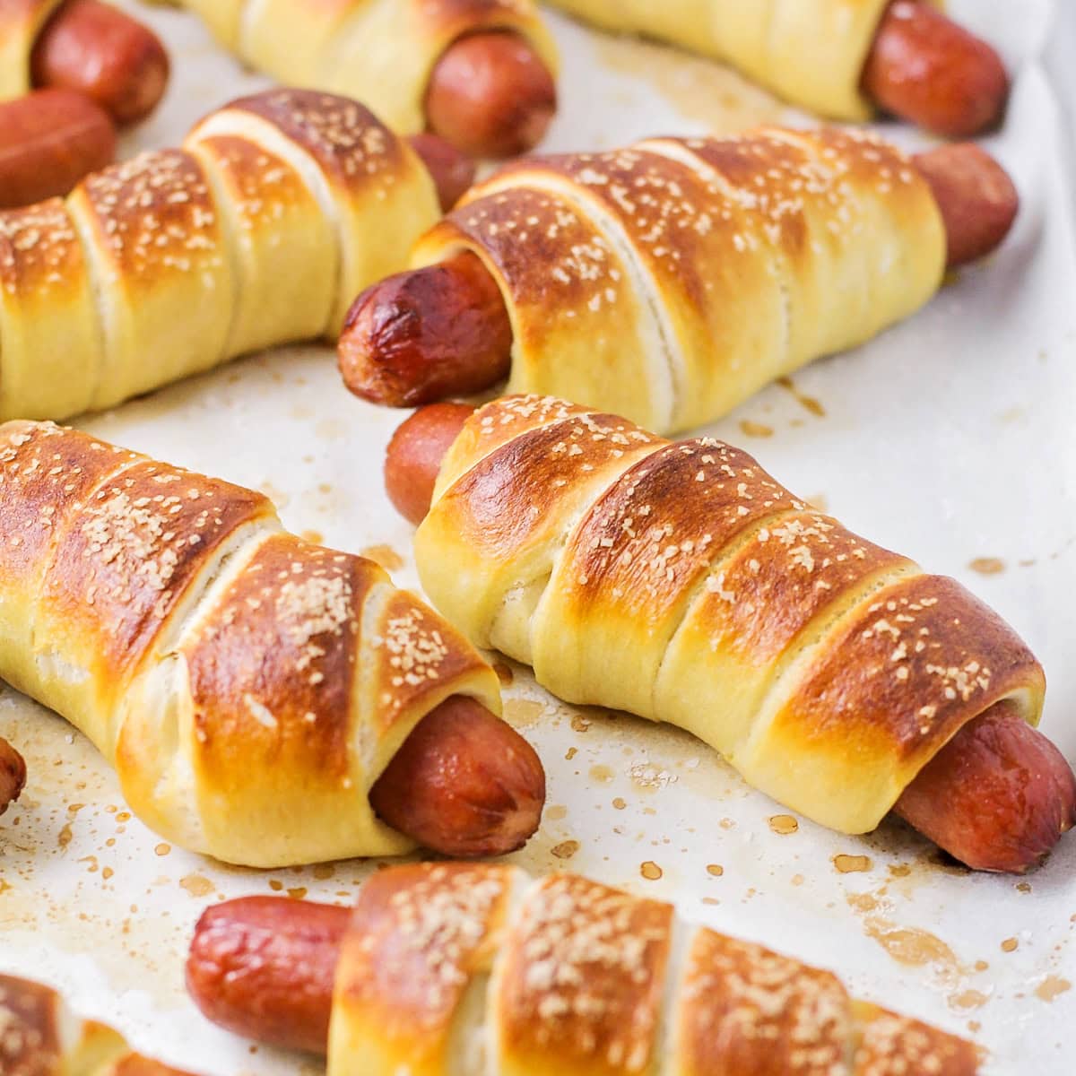 Pretzel dogs on a parchment paper.