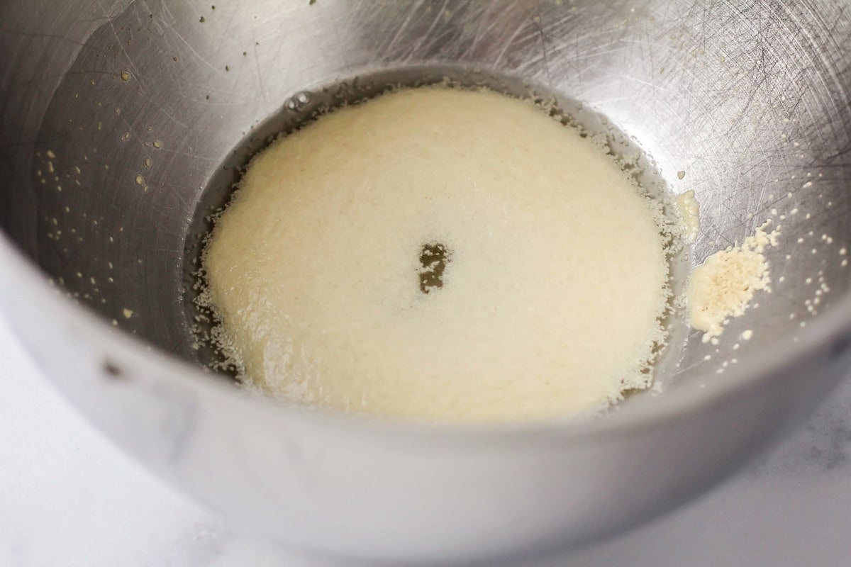 Yeast mixture in a metal bowl.