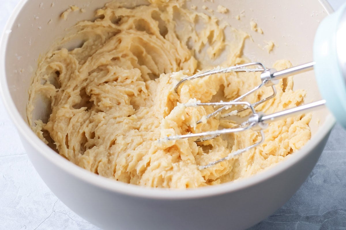 Butter and sugar mixed in a gray bowl.