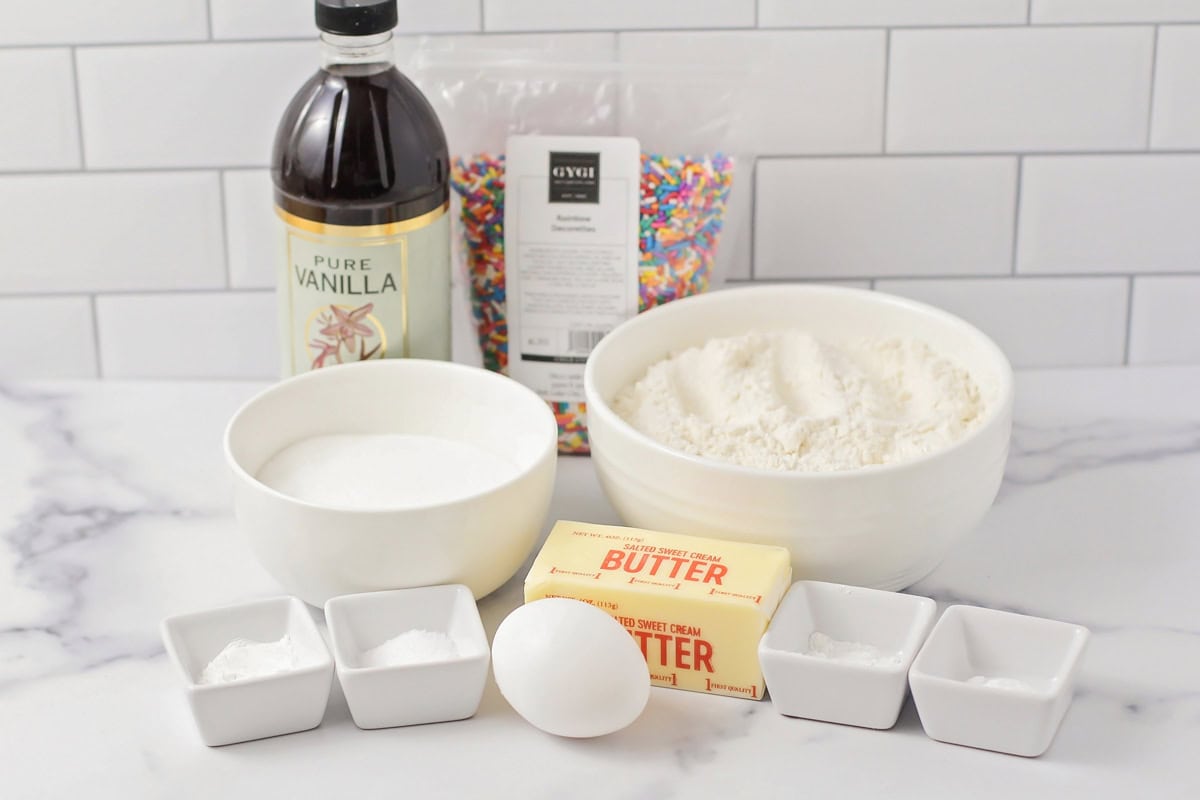 Ingredients for sprinkle sugar cookies on a kitchen counter.