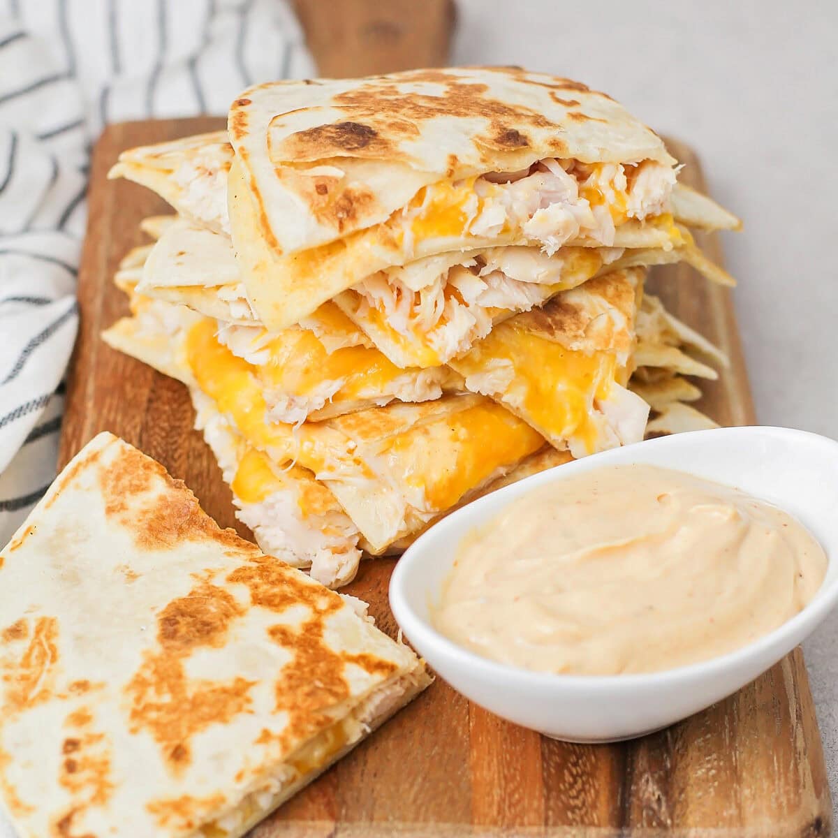 Close up image of chicken quesadillas cut up on cutting board.