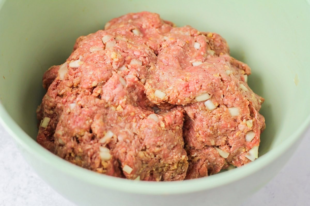 Ingredients for easy meatloaf recipe mixed together in bowl. 