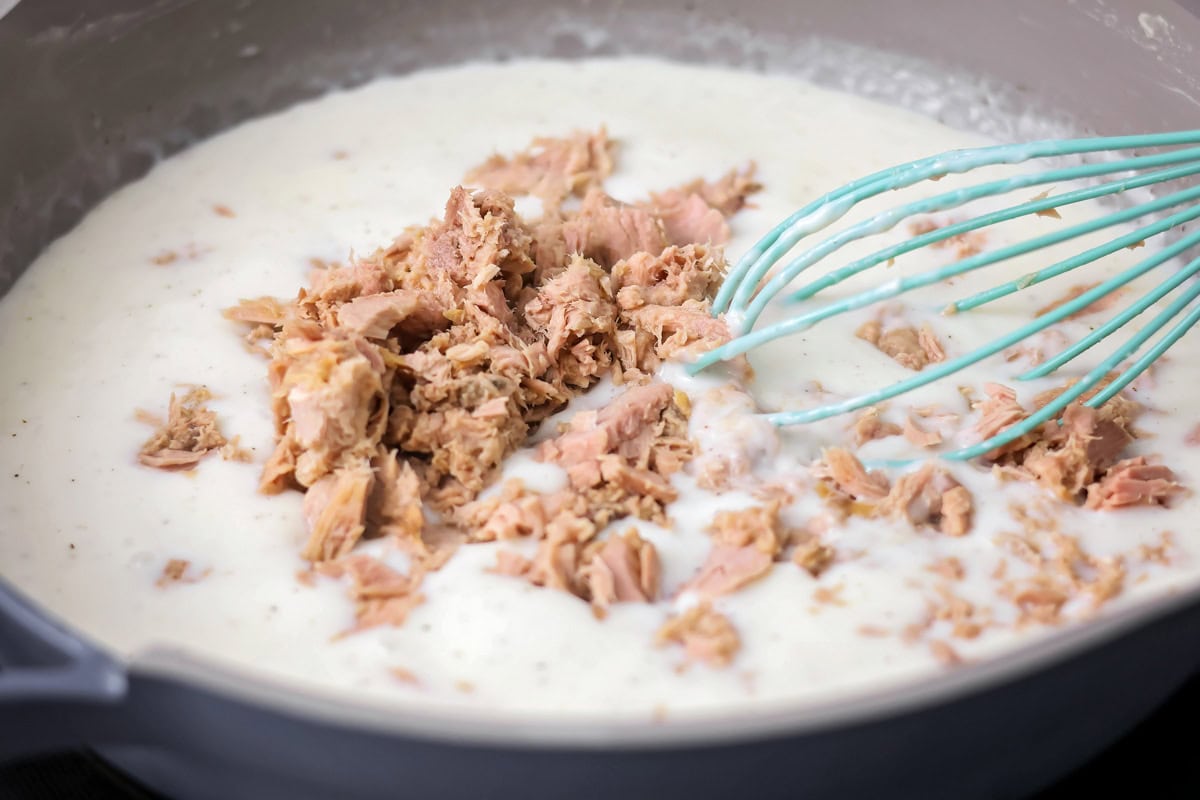 Adding tuna to the white sauce.