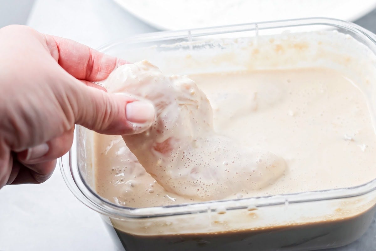 Marinated chicken in a dish of coconut milk.