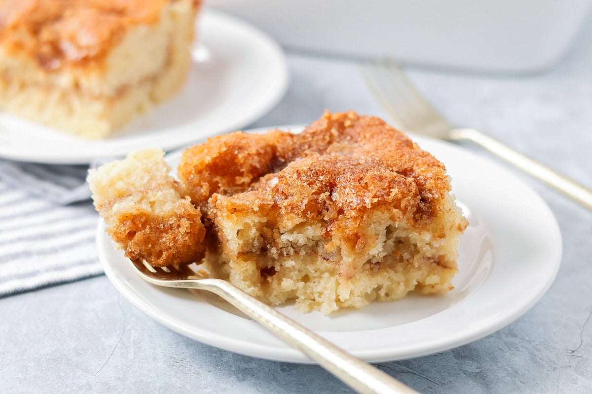Easy coffee cake recipe with bite taken out of it - served on white plate.