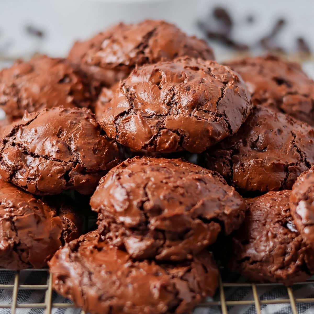 Flour chocolate cookies stacked on a cooling rack.