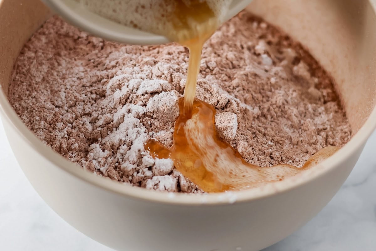 Adding wet ingredients to the dry ingredients.