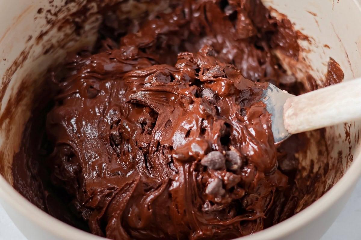 Mixing chocolate chips into the batter.
