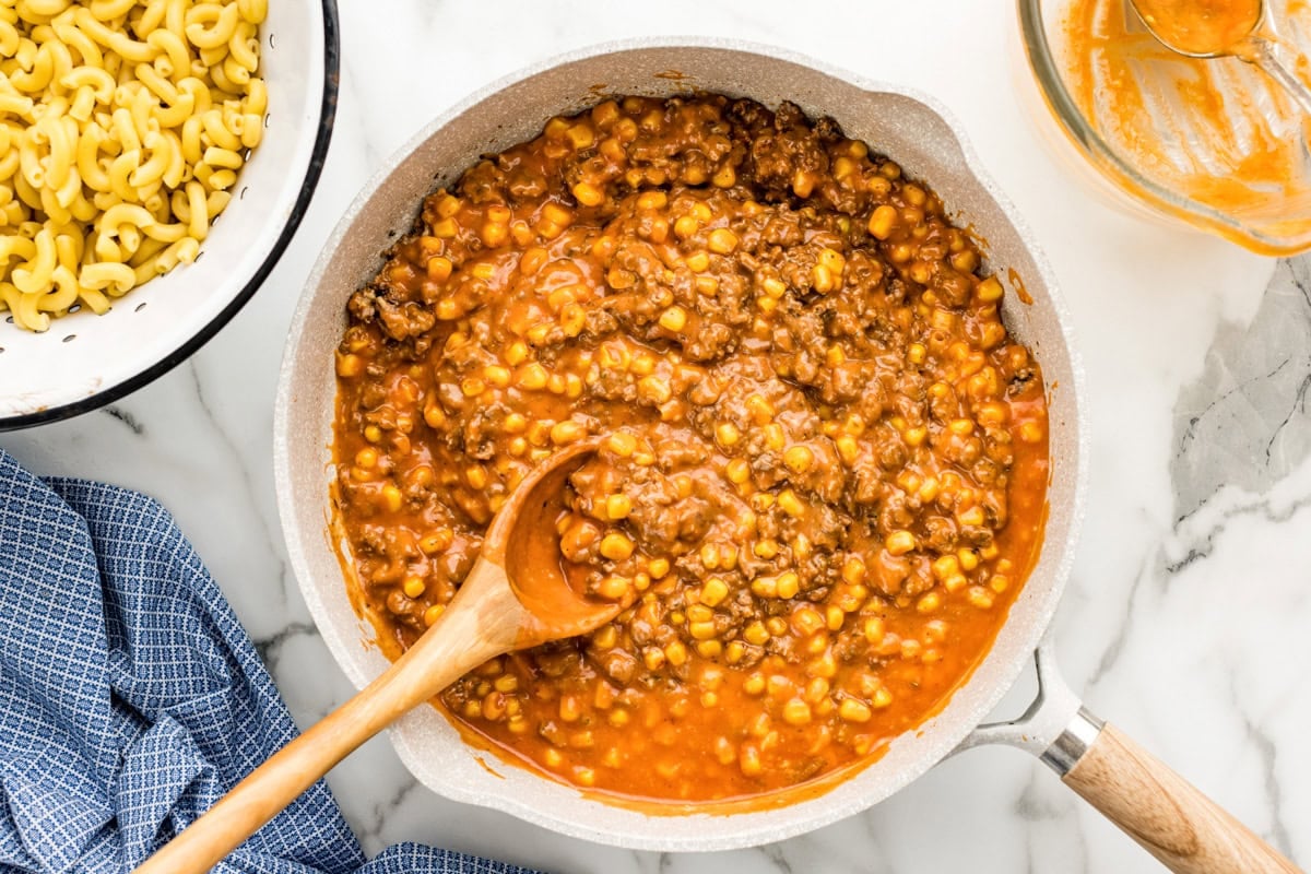 Adding hamburger meat to the sauce.