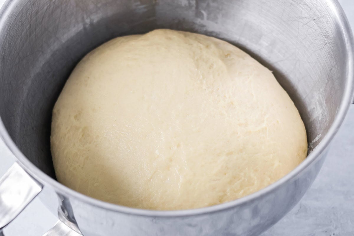 Dough rising in a metal bowl.