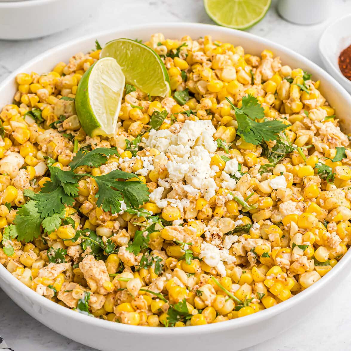Close up image of Mexican street corn salad recipe in white bowl.