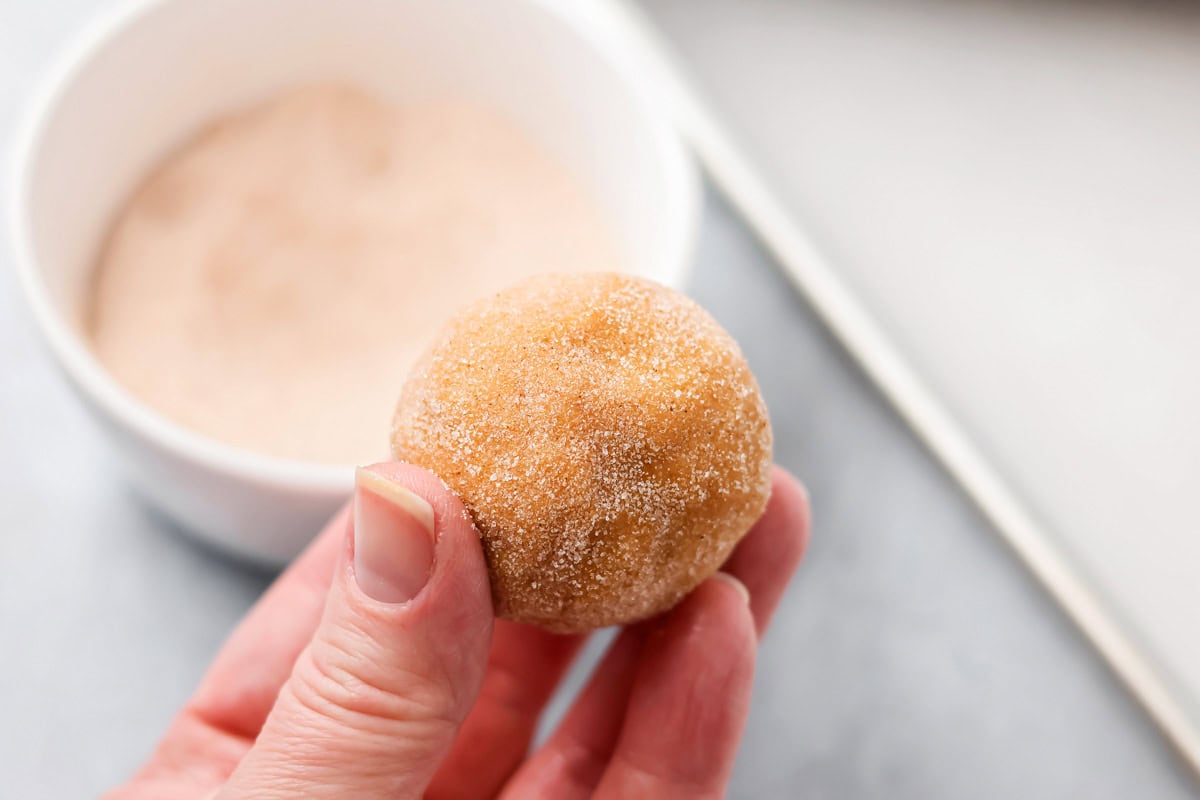 Dipping pumpkin balls into the sugar mixture.