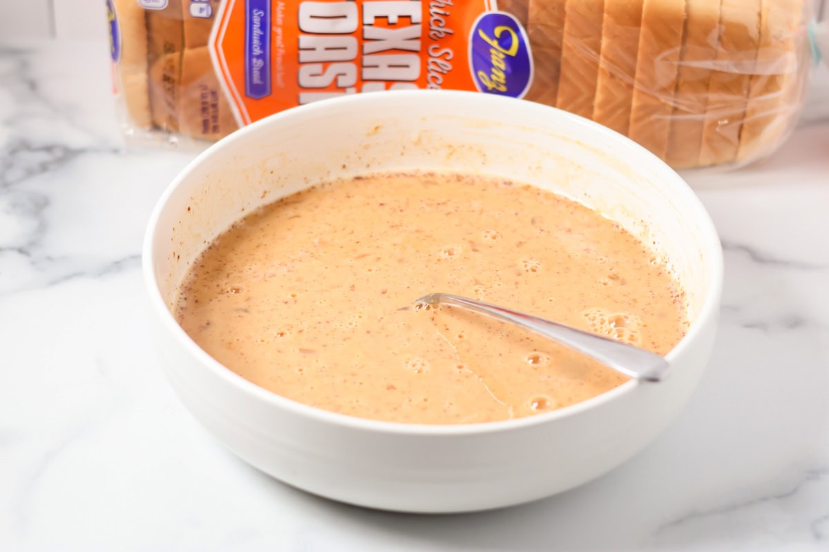 Infused with warm spices and pumpkin, this quick and easy pumpkin French toast transforms breakfast into a cozy, decadent fall favorite! Milk and egg mixture in a white bowl.