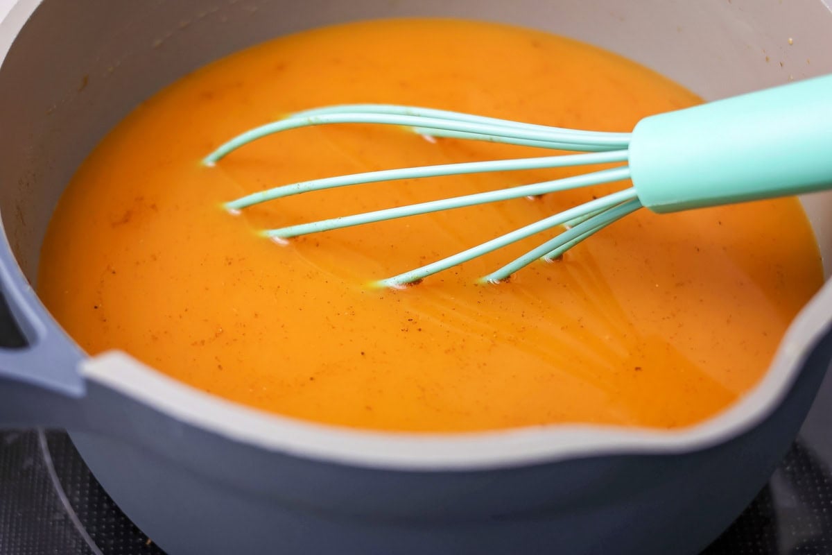 Pumpkin juice, the iconic wizarding world beverage, can be served chilled or heated for a bit of autumn magic in every sip! Stirring a pot of pumpkin juice with a whisk.