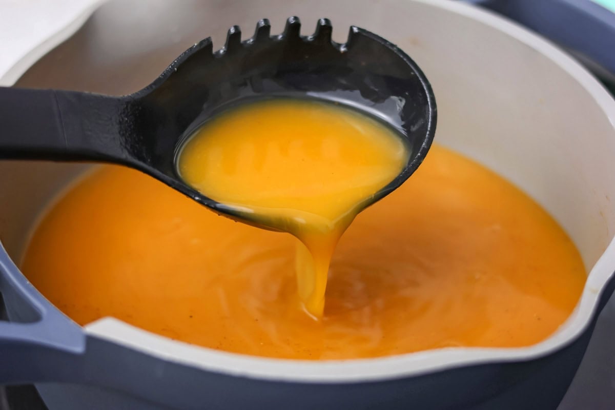 Pumpkin juice, the iconic wizarding world beverage, can be served chilled or heated for a bit of autumn magic in every sip! Scooping a ladle full of pumpkin juice from a pot.