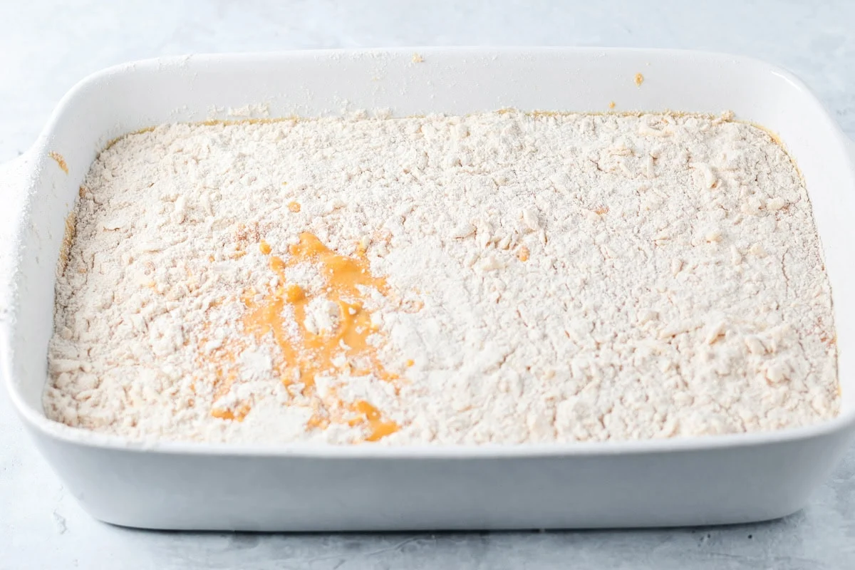 These pumpkin pie bars use a cake mix shortcut to create a fluffy, pumpkin-spiced treat that's perfect for sharing! Pumpkin pie bars ready to be baked.